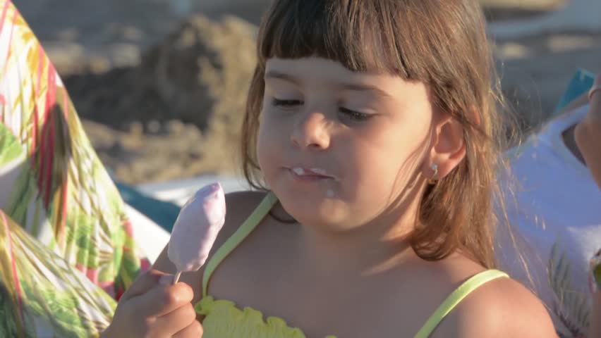 Girl eating ice cream and sitting next to her mother
