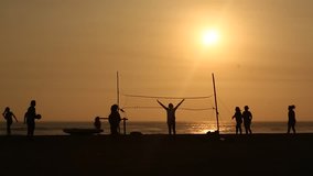 video footage in HD of people playing Volleyball at the beach in the sunset