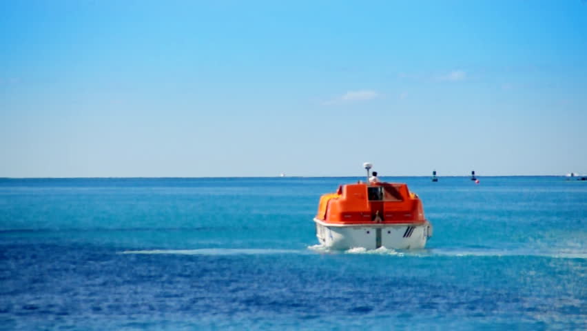Lifeboats from a cruise ship test their engines in a harbor near Nassau in the