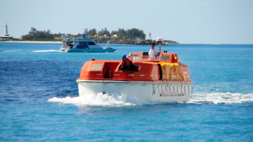 Lifeboats from a cruise ship test their engines in a harbor near Nassau in the
