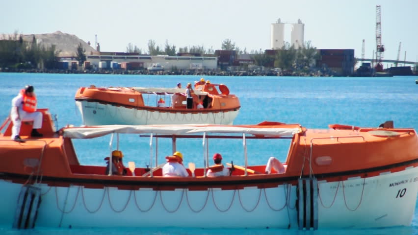Lifeboats from a cruise ship test their engines in a harbor near Nassau in the