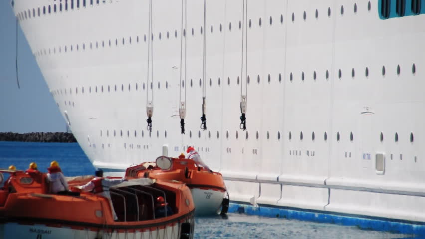 Lifeboats from a cruise ship test their engines in a harbor near Nassau in the