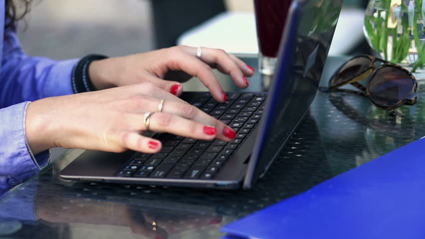 Businesswoman hands typing on laptop computer in cafe
