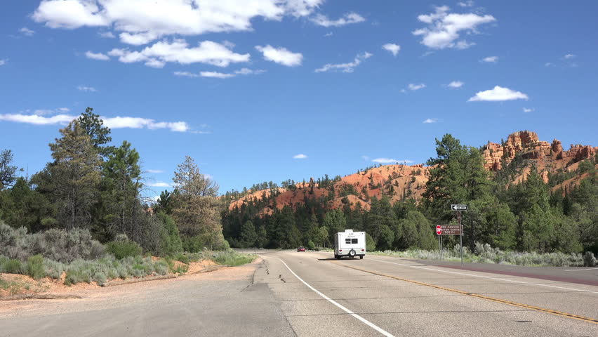  Traffic southwest Utah mountain road Bryce Canyon. Red, orange, white colors of rocks provide spectacular views for park visitors. Designated a National Park in 1928.