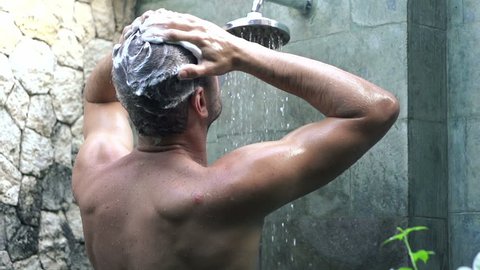 Young man washing hair under shower, super slow motion, shot at 240fps
