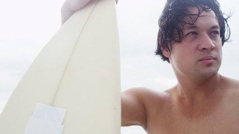 Close up upper body rugged young Hawaiian male surfer living healthy outdoor lifestyle holding his board waiting for waves soft light looking camera shot on RED EPIC