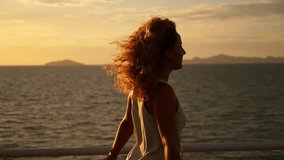 Young Happy Girl with Curly Hair and Tatto Spreading Arms at Beautiful Sunset. Sailing on the Ferry. Motivating Inspiring Slow Motion Video.
