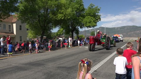 MORONI, UTAH - 4 JUL 2014: Antique old farm tractors rural community parade. Antique farm tractor in annual rural town celebration parade. Historic implements shown proudly as restored vehicles.