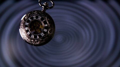Old Pocket Watch Swinging in Slow Motion. Antique pocket clock with hypnosis background.