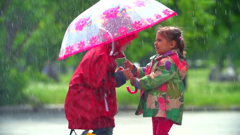 Girl letting boy under her umbrella