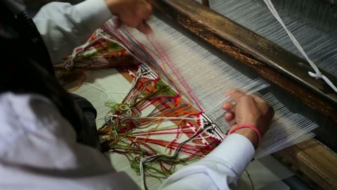 weaver working handloom at workshop, Manali, India.