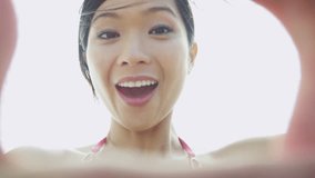 Close up young Asian Chinese girl outdoor beach vacation hands making finger frame smiling face video self portrait shot on RED EPIC