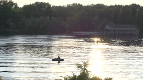  fisherman floats on a rubber boat on the river.