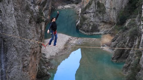France, 2013. A woman tightrope walking over high canyon.