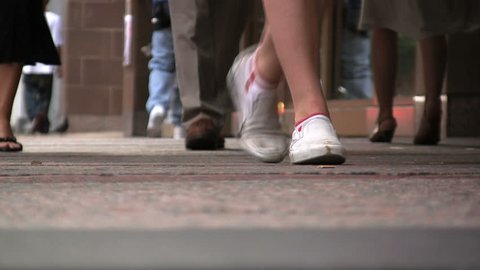 A point of view shot of feet strolling on a Chicago sidewalk. (No Audio) 