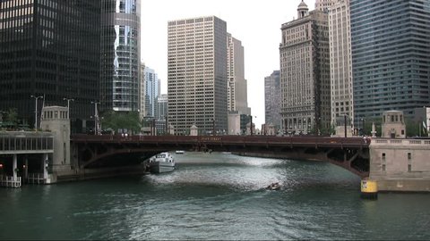 A time lapse of state street over the Chicago river as the sun peaks out and lights some buildings while casting shadows on others. (No Audio)