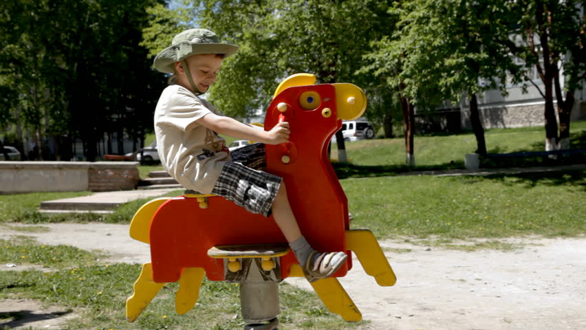 happy boy swing on horse at playground