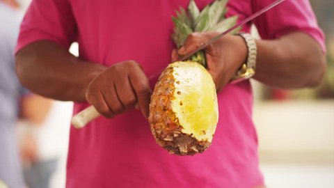 Man cutting fresh Pineapple at a street market 