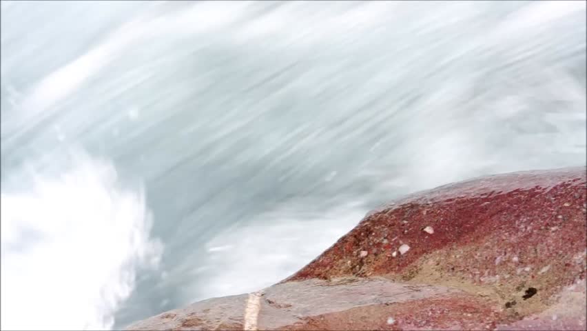 closeup of Red Stone beside fast streaming Mountain River