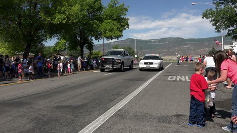 MORONI, UTAH - JUL 2014: Patriotic parade important to citizens of small rural America. End of rural community parade sheriff. Old historic automobile car, tractors, and trucks are main attraction.