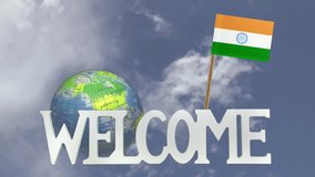 The word WELCOME in front of a turning globe and moving clouds in a blue sky with tooth pick and a small paper flag of INDIA