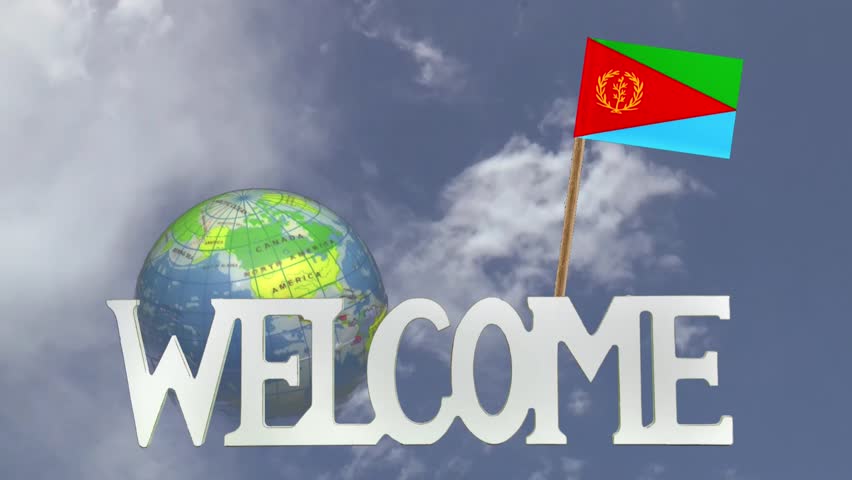 The word WELCOME in front of a turning globe and moving clouds in a blue sky with tooth pick and a small paper flag of ERITREA