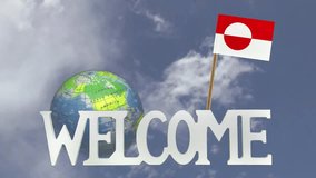 The word WELCOME in front of a turning globe and moving clouds in a blue sky with tooth pick and a small paper flag of GREENLAND