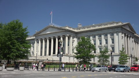 WASHINGTON, DC - MAY 2014: United States Treasury Department building, tourists stroll, Washington, DC. At corner of 15th Street and Pennsylvania Avenue is next to the White House.