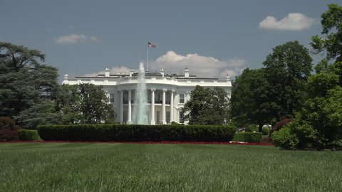 WASHINGTON, DC - MAY 2014: Zoom in over South lawn to White House Oval Office. Tourists can only view the South front from behind a fence some distance from the White house.