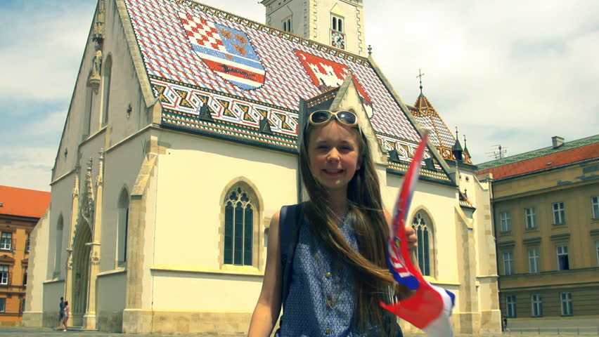 Little girl tourist waving the Croatian flag in St Marks’s Square, Zagreb, Croatia - in slow motion