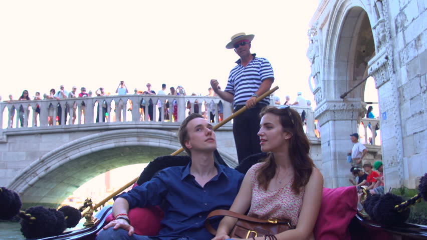 A young couple relax on vacation on a gondola ride in Venice, Italy