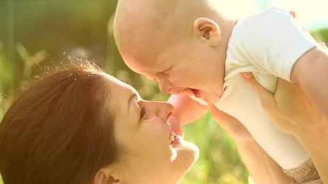 Mother and Baby having fun Outdoors.Together in Green Summer Park. Mom and Child. Happy Family Smiling. Beautiful family in spring park enjoying nature. Slow motion 1920x1080