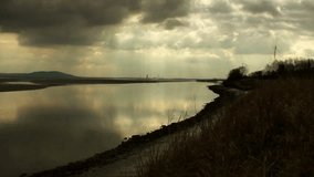 Distant view of smoke pouring from chimneys of petrochemical plant with river in foreground - Powered by Shutterstock - Get 15% off with code: PIKWIZARD15