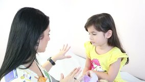 Beautiful therapist preparing a little girl to give a massage