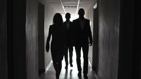 Group of people approaching camera in the dark hallway