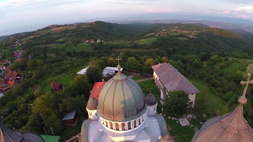 Aerial view over cathedral on countryside in mountains at sunset