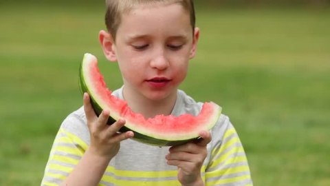 Three different kids taking a huge bite of watermelon