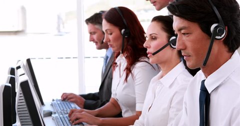 Call centre diverse agents working and talking on headsets in the office