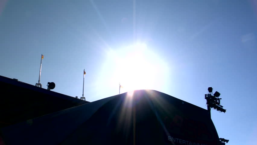 Extreme sports BMX rider spins over the sun in slow motion