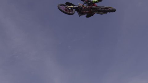 Extreme Sport Motorcycle Rider Doing Jumps on Giant Motocross Jump on a Beautiful Summer Day - Big death defying tricks.
