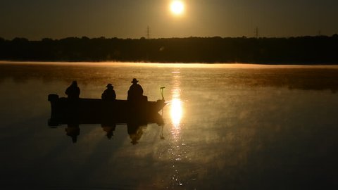 Silhouette of fishermen fishing off a small boat during sunrise on the Hoover Memorial Reservoir. Hoover Dam HD 1080p Ohio nature beauty shot. Shot on July 5, 2014.
