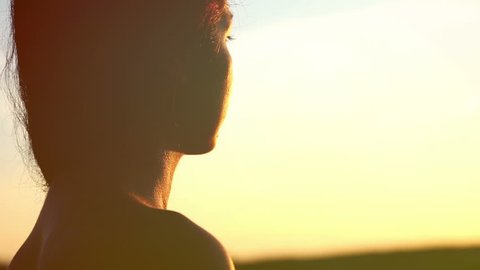 Portrait of a girl at sunset. Silhouette of a girl from the back.