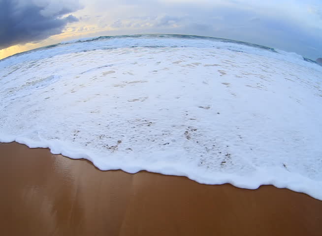 Sea surf wave with foam on shore 