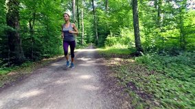 young woman jogging through forest