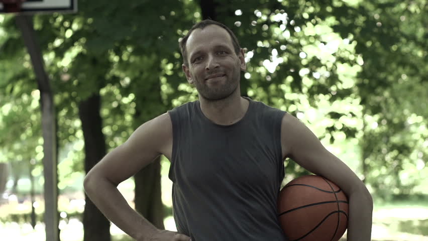 Portrait of happy basketball player in park, super slow motion, 240fps
