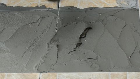 Plasterer spreading concrete on floor