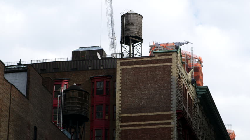 Wide shot of a water tower on the roof of a building in Manhattan