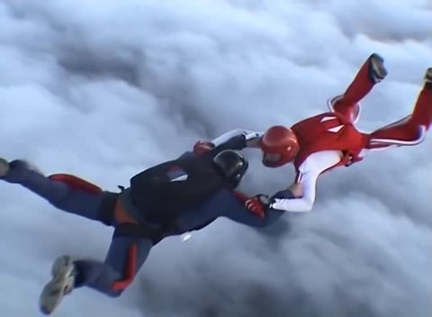 Three men skydive formation in the sky