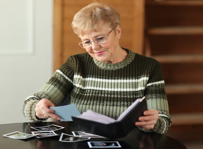 Senior woman viewing photo album in livingroom  
