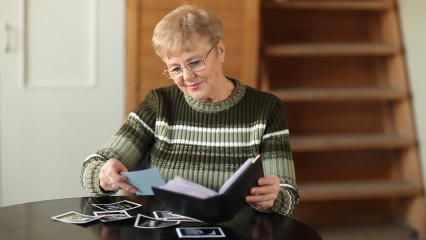 Senior woman viewing photo album in livingroom  